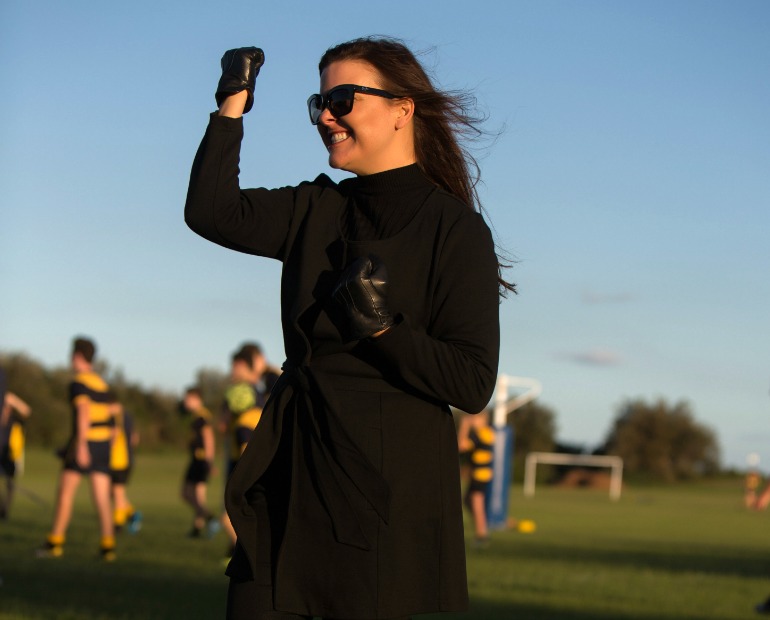 cheering at the footy in a wrap coat